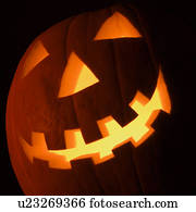 Carved Halloween pumpkin glowing in the dark.