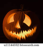 Carved Halloween pumpkin glowing in the dark.