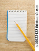 Pencil on top of open spiral bound notepad Pencil on top of open spiral bound notepad