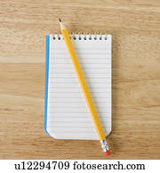 Pencil on top of open spiral bound notepad Pencil on top of open spiral bound notepad