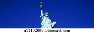 This is the top half of the Statue of Liberty against a blue sky in horizontal format.
